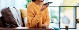 Shot of a young woman using a smartphone on the sofa at home