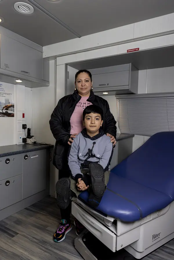 A mother and her young son get health care inside a mobile Care-a-Van in Richmond, VA.