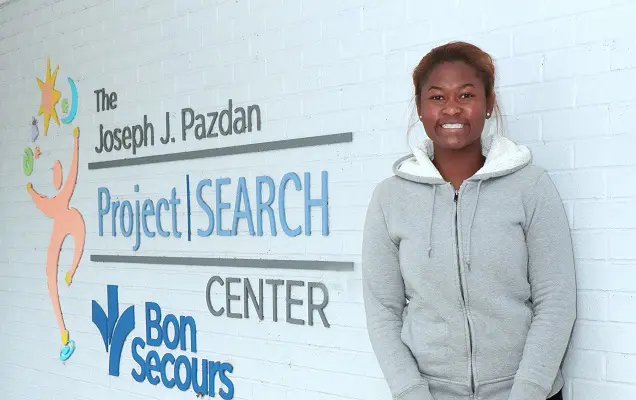 A young woman smiles outside of the Project SEARCH Center.