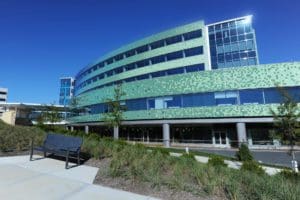 Dynamic clouds and green landscape frame the Mercy Health – Anderson Hospital in Cincinnati, Ohio.