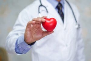 Doctor holding red heart in his hand