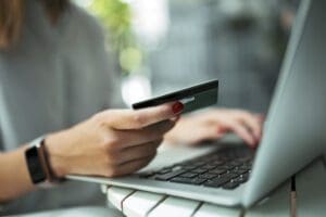 Woman with credit card and laptop.