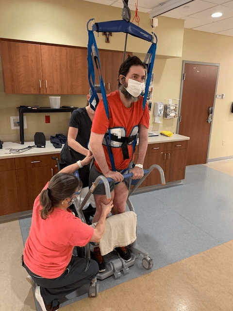 Two Mercy Health nurses help a patient using an Arjo Walking System.