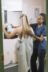 Doctor prepares a woman for a mammogram.