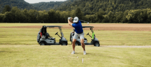 A man tees up to golf on a golf course.