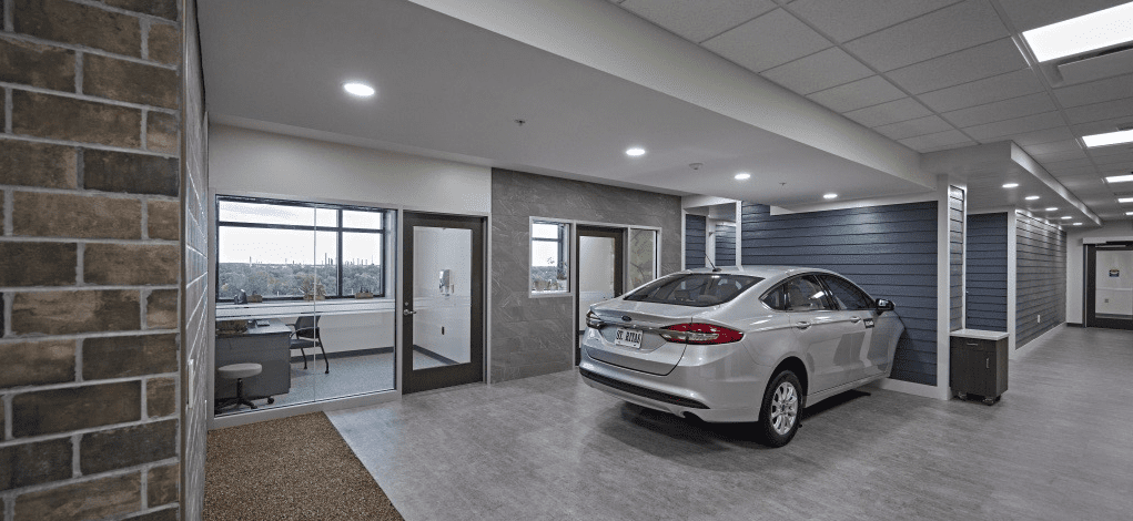 The interior of a rehabilitation facility with a full-sized car for patients to practice on.