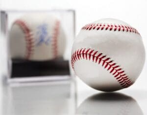 An autographed baseball in a glass display case.