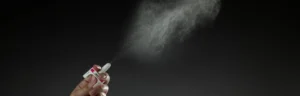 A hand spraying a dose of naloxone nasal spray.