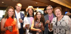 A group of Bowties & Bourbon 2024 guests pose together with their drinks.