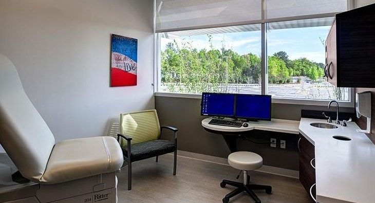 A 3D rendering of a medical consultation room.