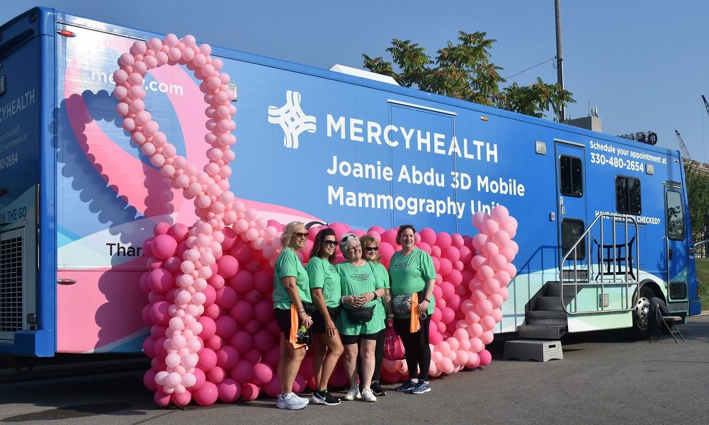 Runners pose for pictures in front of a mobile mammography van during Panerathon in Youngstown, OH.