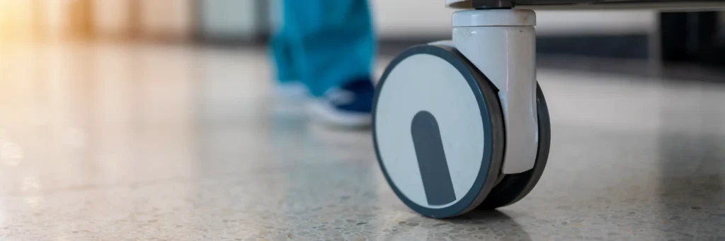 A nurse pushing a cart down a hospital hallway.