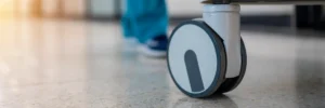 A nurse pushing a cart down a hospital hallway.