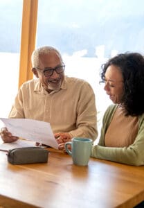 Two people sitting at a table and looking over a document