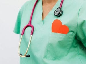 nurse with paper heart in pocket