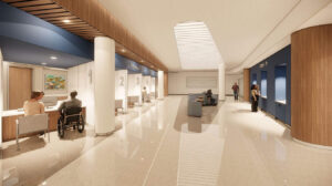 A spacious, modern hospital lobby with numbered registration desks, wood paneling, and skylights. People sit and stand, creating a calm, welcoming atmosphere.