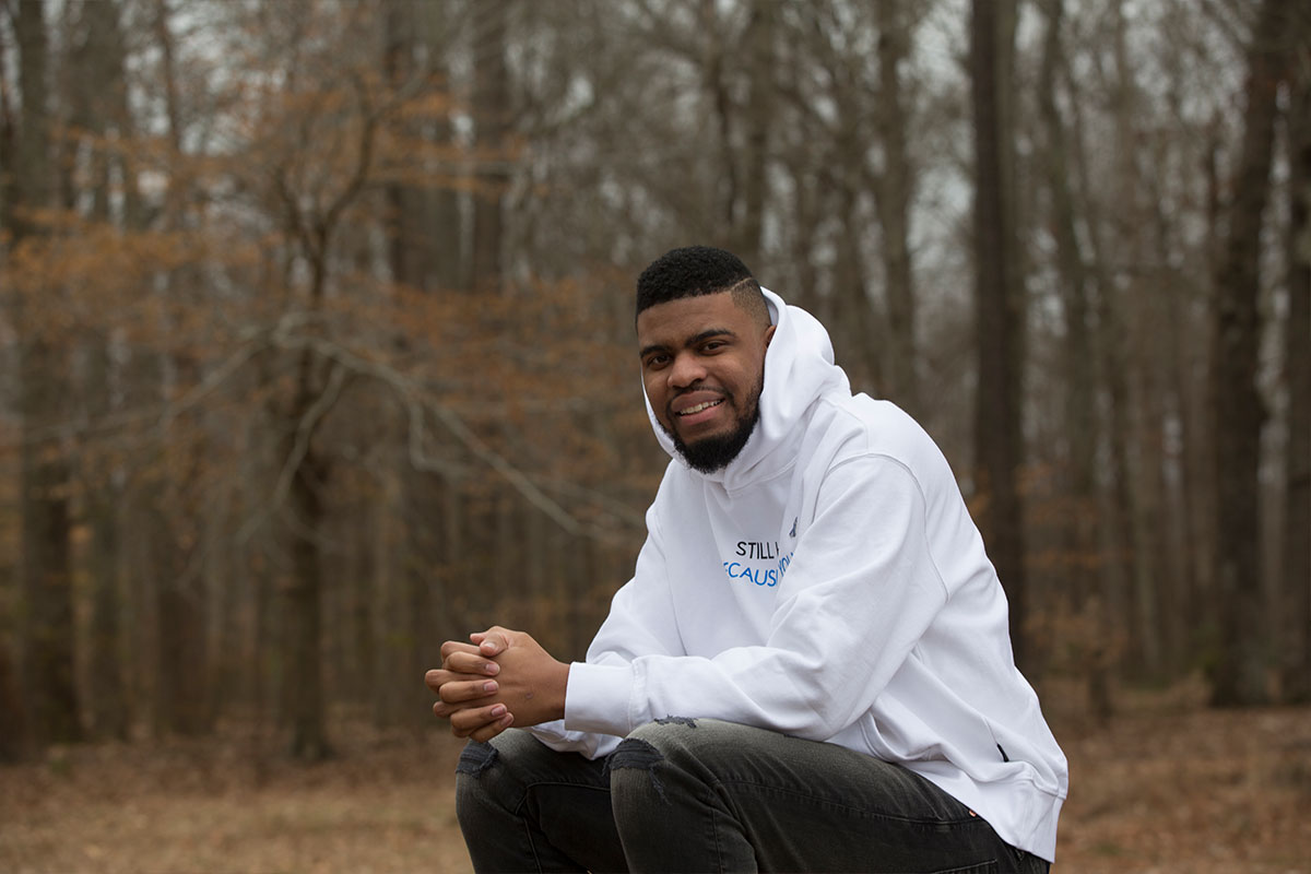 Deylon sits outside