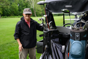 golfer standing next to cart on course