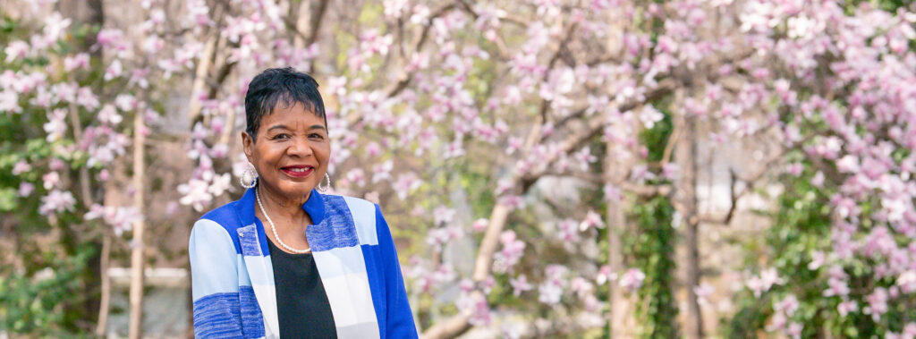 Joyce Lanier standing by trees