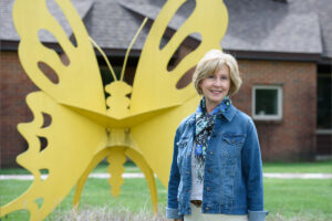 Lucy Regueyra standing outside by butterfly