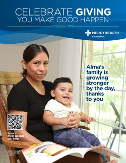 Campaign banner for Celebrate Giving by Merck Foundation showing a woman with a baby reading a magazine by a window; overlay text mentions Alma's family growing stronger by the day, thanks to you, and a QR code in the bottom left.