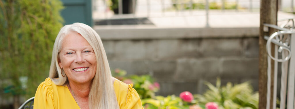 Landscape portrait of Karen Grothouse outside in a garden