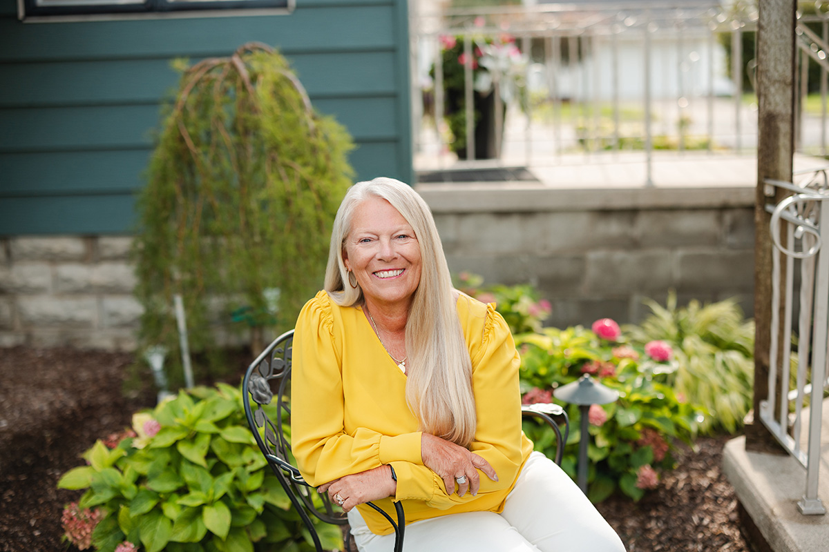 Landscape portrait of Karen Grothouse outside in a garden