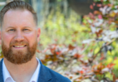 Chase Collins, director of neurosciences, stands in front of Mercy Health's Springfield Regional Medical Center hospital. He is a middle-aged white man with reddish hair and beard.