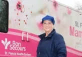 A woman stands beside a mobile mammography coach in Greenville, SC.