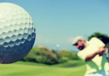 Golfer hits a golf ball