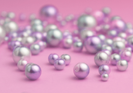 Pearls scattered across a pink backdrop.